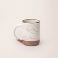 The Mug Jeune femme le visage enfoui dans les bras